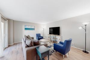 ペンサコーラ・ビーチにあるBoardwalk A20のソファと椅子とテレビのあるリビングルーム