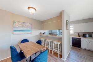 ペンサコーラ・ビーチにあるBoardwalk A20の木製のテーブルと椅子のあるキッチンとダイニングルーム
