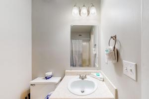 ペンサコーラ・ビーチにあるBoardwalk A20の洗面台と鏡のある白いバスルーム +16枚の写真