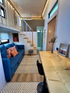 a living room with a blue couch and a wooden table at Tiny House By The Beach in Mazatlán