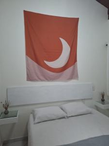 a flag hanging above a bed in a bedroom at Apartamento na Barra de Ibiraquera in Imbituba