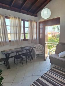 a dining room with a table and chairs and a couch at Apartamento na Barra de Ibiraquera in Imbituba