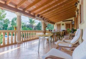 een veranda met een tafel en stoelen op een balkon bij Villa Son Tugores in Lloseta