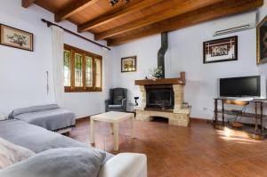 een woonkamer met een bank en een open haard bij Villa Son Tugores in Lloseta