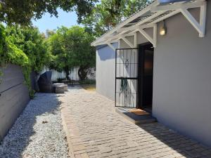 a door to a white building with a gate at 23 Belladonna Cottage in Hermanus