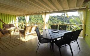 patio con mesa y sillas en el balcón en Mango Lodge Villa, en Portsmouth