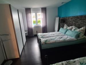 a bedroom with a bed and a blue wall at Monteurwohnung in Bad Neustadt an der Saale