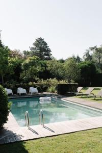 een zwembad met stoelen in de tuin bij Maison d'exception au Touquet in Le Touquet-Paris-Plage