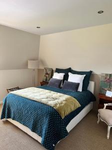 um quarto com uma cama grande com lençóis azuis e brancos em ailleurs sous les etoiles em Manneville-la-Raoult