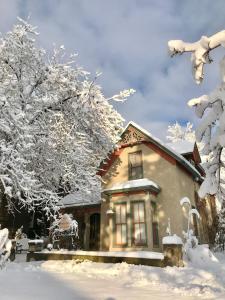 a house with snow covered trees in front of it at Pansy’s Parlor Bed & Breakfast in Golden +28 photos