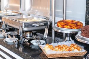 a buffet line with a turkey and other foods at Foz Budget Hotel in Foz do Iguaçu