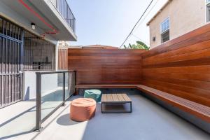una terraza con un banco y una pared de madera en Peaceful Getaway in the Heart of K-Town 2B 2B N, en Los Ángeles