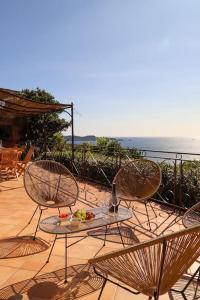 a patio with chairs and a table with food on it at Villa Terracotta - Stunning Sea View & Pool in Carqueiranne