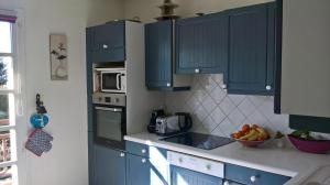 ヴェリエ・デュ・ラックにあるMaison avec Piscine LAC d'ANNECY - proximité Plage VEYRIER DU LACのキッチン(青いキャビネット、フルーツボウル付)