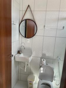La salle de bains est pourvue d'un lavabo, de toilettes et d'un miroir. dans l'établissement Pousada Sumaré, à Caruaru