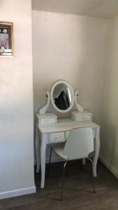 een witte kaptafel met een spiegel en een stoel bij cozy room with private bathroom in Arlington