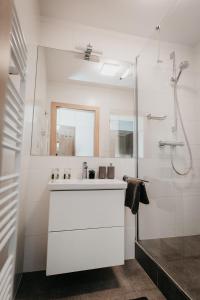 a white bathroom with a sink and a shower at Old Town city center apartment 2 - private parking included in Košice