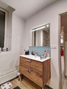 La salle de bains est pourvue d'un lavabo et d'un miroir. dans l'établissement Appart avec jardin, parking privé, calme, prox CV, à Gap
