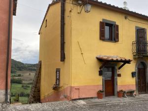 un bâtiment jaune avec une porte et une fenêtre dans l'établissement Casa vacanze Il Geranio, à Celleno