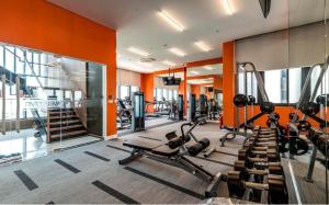 a gym with cardio equipment in a room with orange walls at Riviera Point Apartment 5 star in Ho Chi Minh City