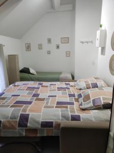 a bedroom with a bed with a quilt on it at L'escale CDG Astérix Park d'exposition in Louvres