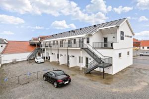 a black car parked in front of a building at Hotel Litorina Appartements in Løkken