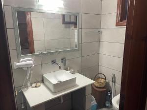 uma casa de banho com um lavatório e um espelho em Gerani em Vasilikos