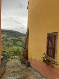 un bâtiment jaune avec une fenêtre et une boîte de fleurs dans l'établissement Casa vacanze Il Geranio, à Celleno