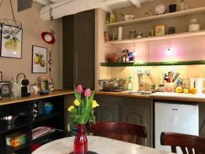 a kitchen with a table with a vase of flowers at Maisonnette au pied du Mont Ventoux ste colombe in Bédoin +10 photos