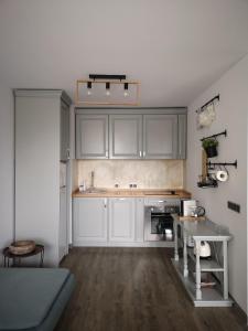 a kitchen with white cabinets and a table at Silver Mountain B12 in Poiana Brasov