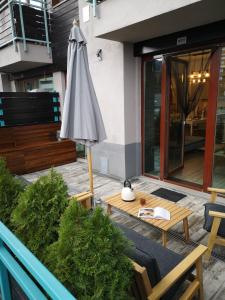 een patio met een parasol en een tafel en stoelen bij Silver Mountain B12 in Poiana Brasov