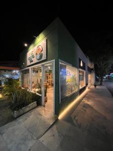 un edificio verde con luces delante de él por la noche en Free! Hostel Vila, en Pipa