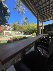 drewniany stół na patio z krzesłami w obiekcie Free! Hostel Vila w mieście Pipa
