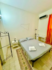 una camera da letto con un letto e due asciugamani di Oasi Palermitana a Palermo