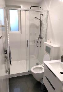 a white bathroom with a shower and a toilet at Dom gościnny 4 JAWA II in Tuczempy