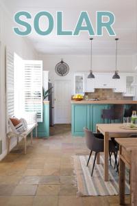 a kitchen with blue cabinets and a table and chairs at La Belle Vie in Franschhoek