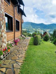 a stone path next to a house with flowers at Montebello Colibita in Colibiţa
