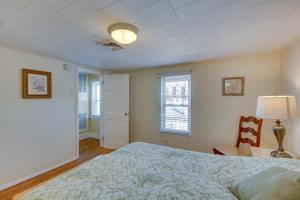 1 dormitorio con cama, lámpara y silla en Wildwood House with Enclosed Porch - Walk to Beach! en Wildwood