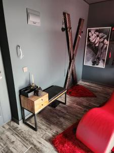 sala de estar con silla roja y mesa en Love freedom bdsm, en Iaşi