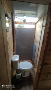 a small bathroom with a toilet and a window at casita en la montaña, cabañas paraíso in Sesquilé