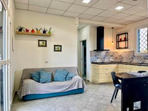 a living room with a bed and a kitchen at Casa Zefiro, tra pineta e mare! in Fregene