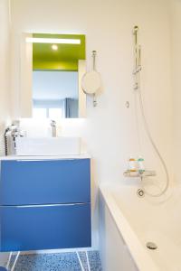 a bathroom with a blue sink and a mirror at Hôtel La Baie des Anges, son SPA marin & sa piscine couverte et chauffée in Landéda