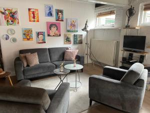a living room with a couch and two chairs at Finca Noordwijk heerlijk huis centrum Noordwijk in Noordwijk