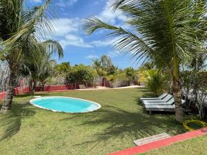 a swimming pool in a yard with palm trees at DECK HOUSE in Tatajuba