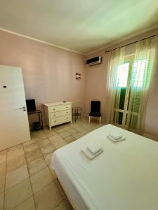 una camera con letto bianco, cassettiera e finestra di Oasi Palermitana a Palermo