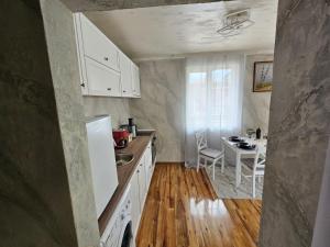 a kitchen with white cabinets and a table in it at Апартамент за гости Боляри in Velingrad