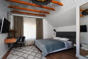 una camera con letto, scrivania e soffitto di Загородный дом с камином и ванной у окна с видом на лес a Novosilki