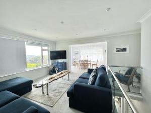 a living room with a blue couch and a table at Incredible Views in Dartmouth with Parking and EV Charger in Dartmouth