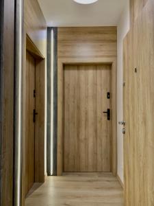 a hallway with a wooden door in a building at REMAR - Apartamentai prie Biale Ežero in Augustów