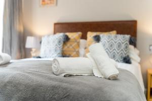 a bed with two rolled towels on top of it at The Gower Hotel in Swansea